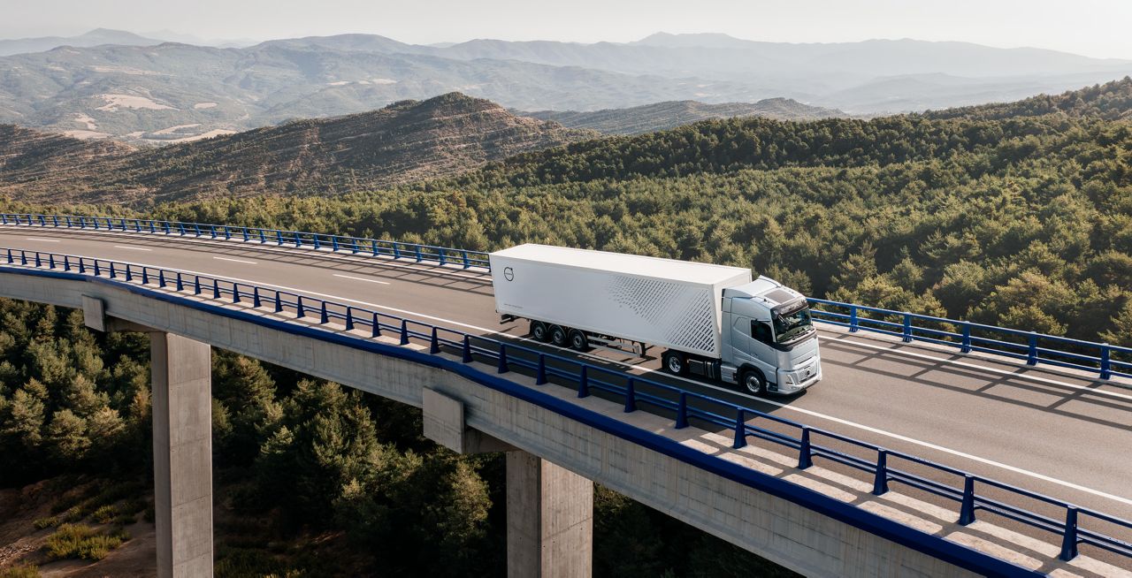 Vrachtwagen rijdt internationaal en over een brug over een prachtig landschap