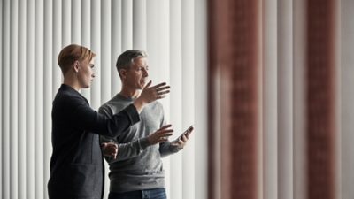Two persons in conversation watching something at a distance.