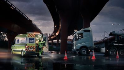 En Volvo Action Service-tekniker parkert under en bro ved siden av en lastebil