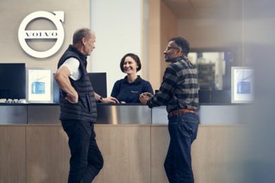 A Volvo representative speaks to a customer while holding a tablet 