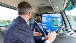 EPA administrator Regan speaks with Volvo Truck employee Brett Pope, as he prepares for his first test drive in the Volvo VNR Electric regional haul model. 