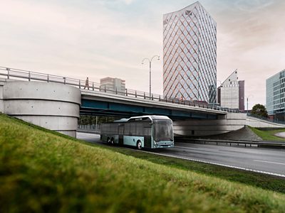 A Volvo 8900 Electric bus on the road on the outskirts of a modern city
