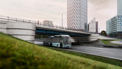 A Volvo 8900 Electric bus on the road on the outskirts of a modern city
