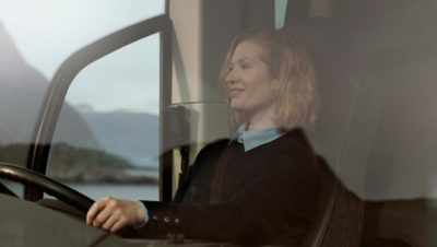 Female bus driver behind the wheel of a Volvo 9700 DD