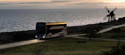 A Volvo 9700 DD driving at dusk on a seaside road