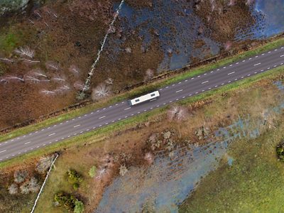 A Volvo 9700 Double Decker driving on a road through marsh