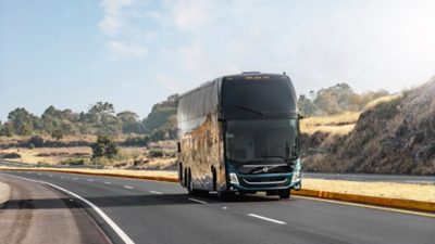 A Volvo 9800 Double Decker 6x2 driving on motorway through landscape.