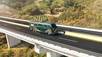 Side view of a Volvo 9800 Double Decker driving on an elevated section of a motorway.