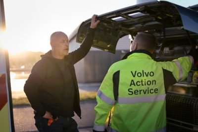 Mechanik Volvo Action Service hovořící s mužem vedle nákladního automobilu