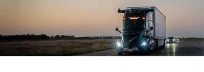 Volvo autonomous truck on the road with headlights turned on