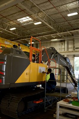 A Volvo CE employee adds a product sticker to an EC230 Excavator on the production line at the Shippensburg facility. 