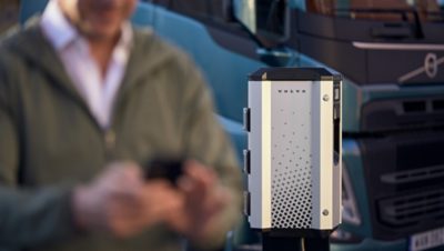 Man starting charging in phone with electric vehicle charger in background