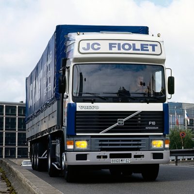 Frontansicht eines Volvo F10 Lkw mit Ladeluftkühler mit JC Fiolet-Branding, der in einer Stadt fährt.