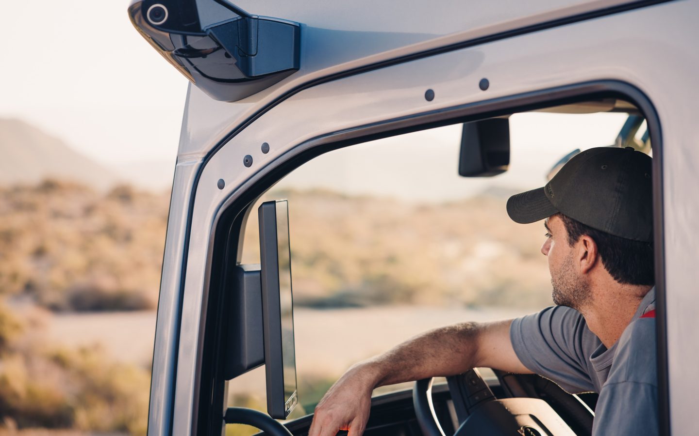 Man in truck resting his arm on the steering wheel