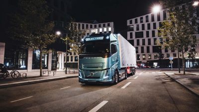 Eine Reihe von Elektro-Trucks von Volvo am Rand einer nicht fertiggestellten Brücke