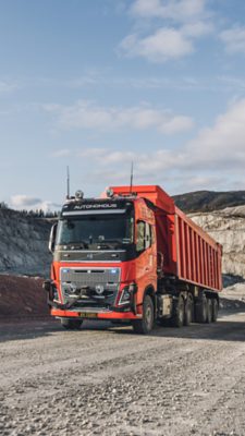 Orange autonomous truck driving in a quarry