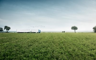 Volvo FH alimenté au gaz roulant à travers des champs ouverts, vu de côté