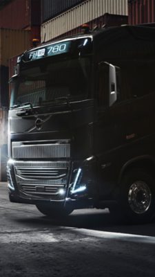 Volvo FH zaparkované mezi kontejnery ve tmavém skladu