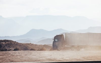 Truck driving in dusty setting