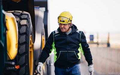 Man met helm loopt naast een vrachtwagen