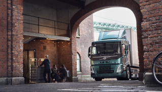 Een Volvo Electric FM truck levert goederen af.