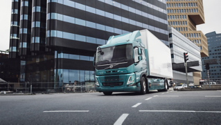 „Volvo“ elektrinis kėbulinis sunkvežimis važiuoja mieste.