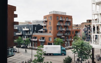 Un Volvo FM Electric roulant en milieu urbain, entouré d'appartements