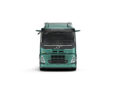 Студийная фотография грузового автомобиля Volvo FM Electric (вид спереди). На фото видна бирюзовая кабина, аэродинамическая решетка и маркировка «ELECTRIC» над лобовым стеклом.