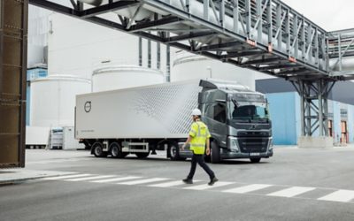 Pedestrian crossing road. Volvo FM in the back