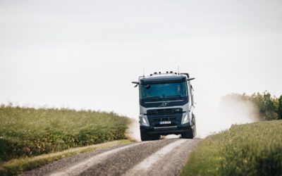 A man inside a truck with hands on the steering wheel