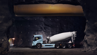 „Volvo“ elektrinis sunkvežimis su betono maišykle statybvietėje.