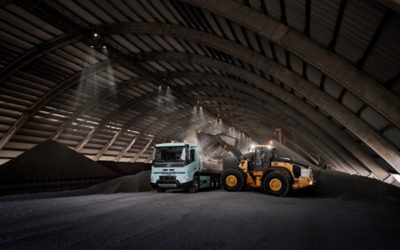 A tractor loads a Volvo FMX Electric