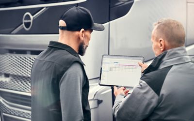 Two man standing next to each other, looking at a tablet