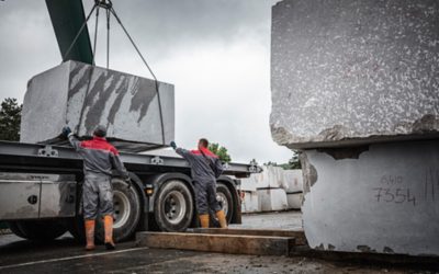 Two men unloading boulders