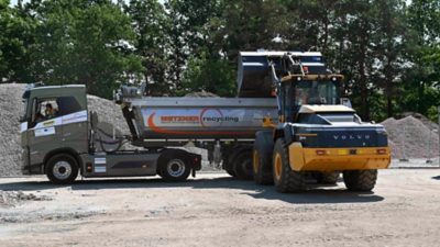 Elektrischer Volvo FH Sattelzug und Volvo L120 Electric Radlader von Metzner Recycling beim Beladen von Bauschutt auf der emissionsfreien Baustelle in Erlangen.