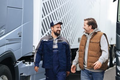 Volvo-mekaniker og lastbilchauffør kigger smilende på hinanden