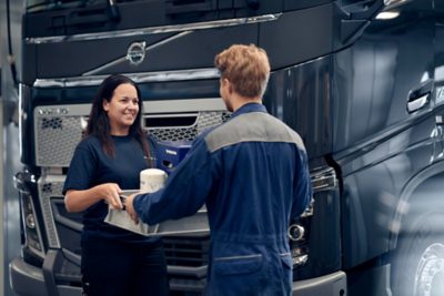 Onderdelenvertegenwoordiger overhandigt originele Volvo-onderdelen aan technicus