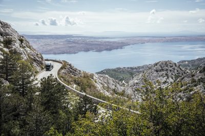 A truck drives along a winding coastal road