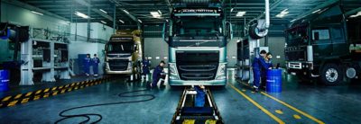 A team of Volvo service technicians services a variety of Volvo trucks in a workshop