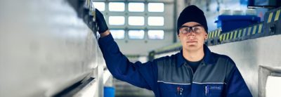 A Volvo service technician works on a part inside a workshop