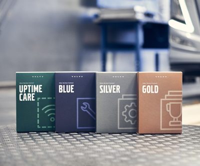 Kutije koje predstavljaju Volvo servisne ugovore, raspoređene po radnoj površini u ambijentu radionice, prikazuju različite nivoe servisnih ugovora.