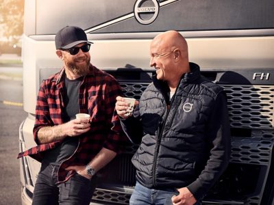 Volvo-lastbilchauffør og kørselsleder drikker kaffe foran Volvo FH