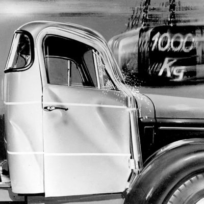 Schwarzweißbild eines frühen Crashtests eines Volvo-Lkw, bei dem ein Gewicht von 1.000 kg auf das Fahrerhaus aufprallte, um die strukturelle Integrität zu beurteilen.