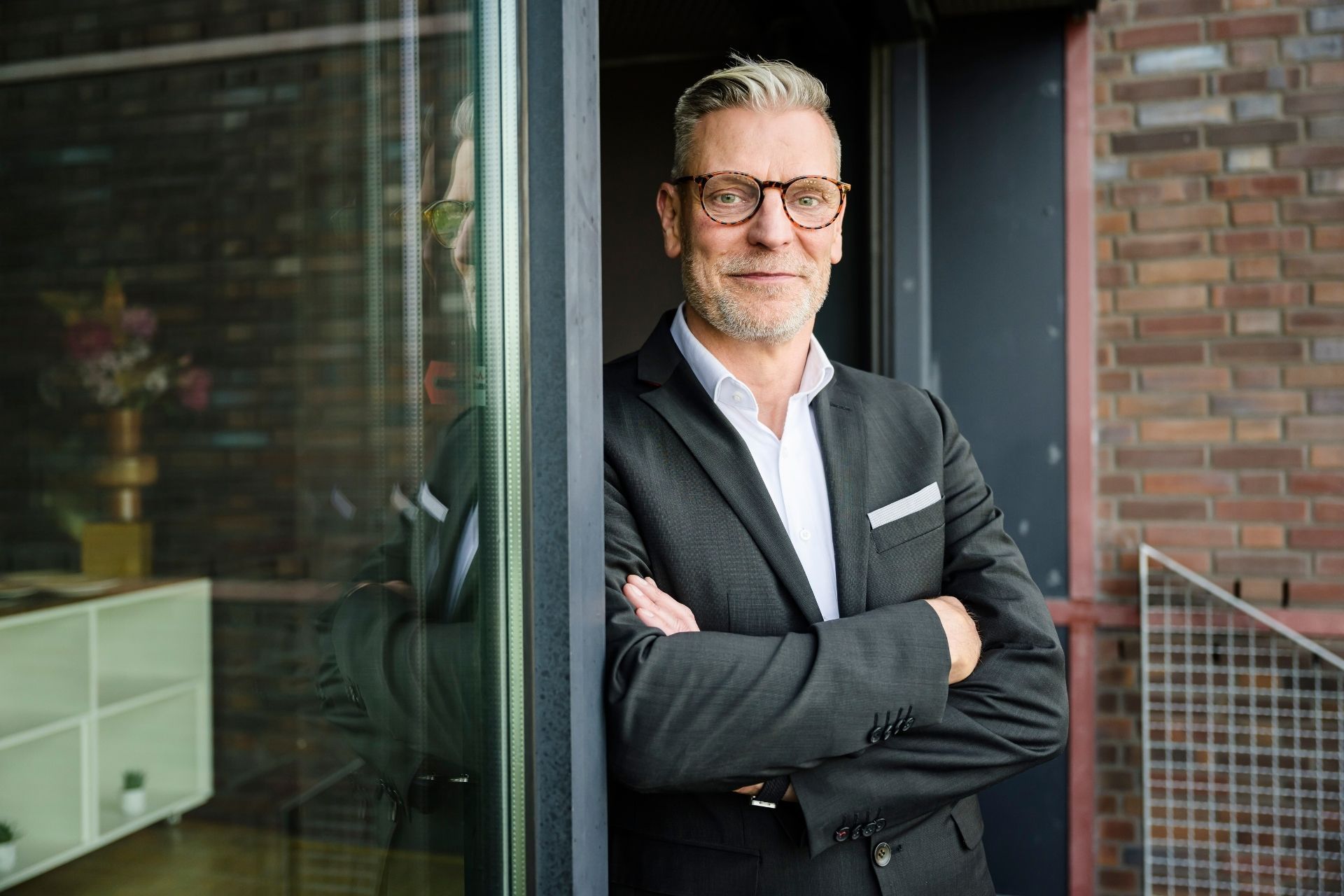Markus Weckesser, neuer Geschäftsführer von Volvo Trucks Deutschland, steht mit verschränkten Armen und lächelt in die Kamera.