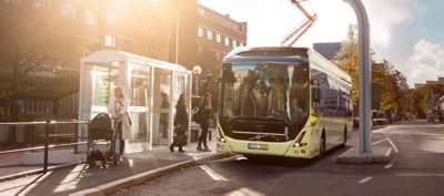 Un autobús Volvo cargando en la parada de autobús. Llave en mano de Volvo, una oferta de movilidad eléctrica con todo incluido.