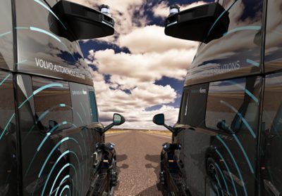Two trucks from the front door onwards in frame side by side facing an open road