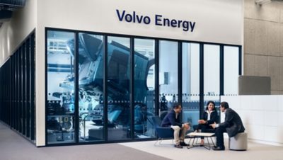Volvo Energy's BESS at a port with sea and wind turbines backdrop.