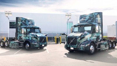 Volvo VNR Electric models parked in front of 150 kW chargers at Volvo Trucks customer NFI’s Chino, California facility