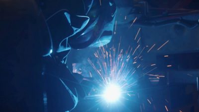 a volvo bus employee using a welder